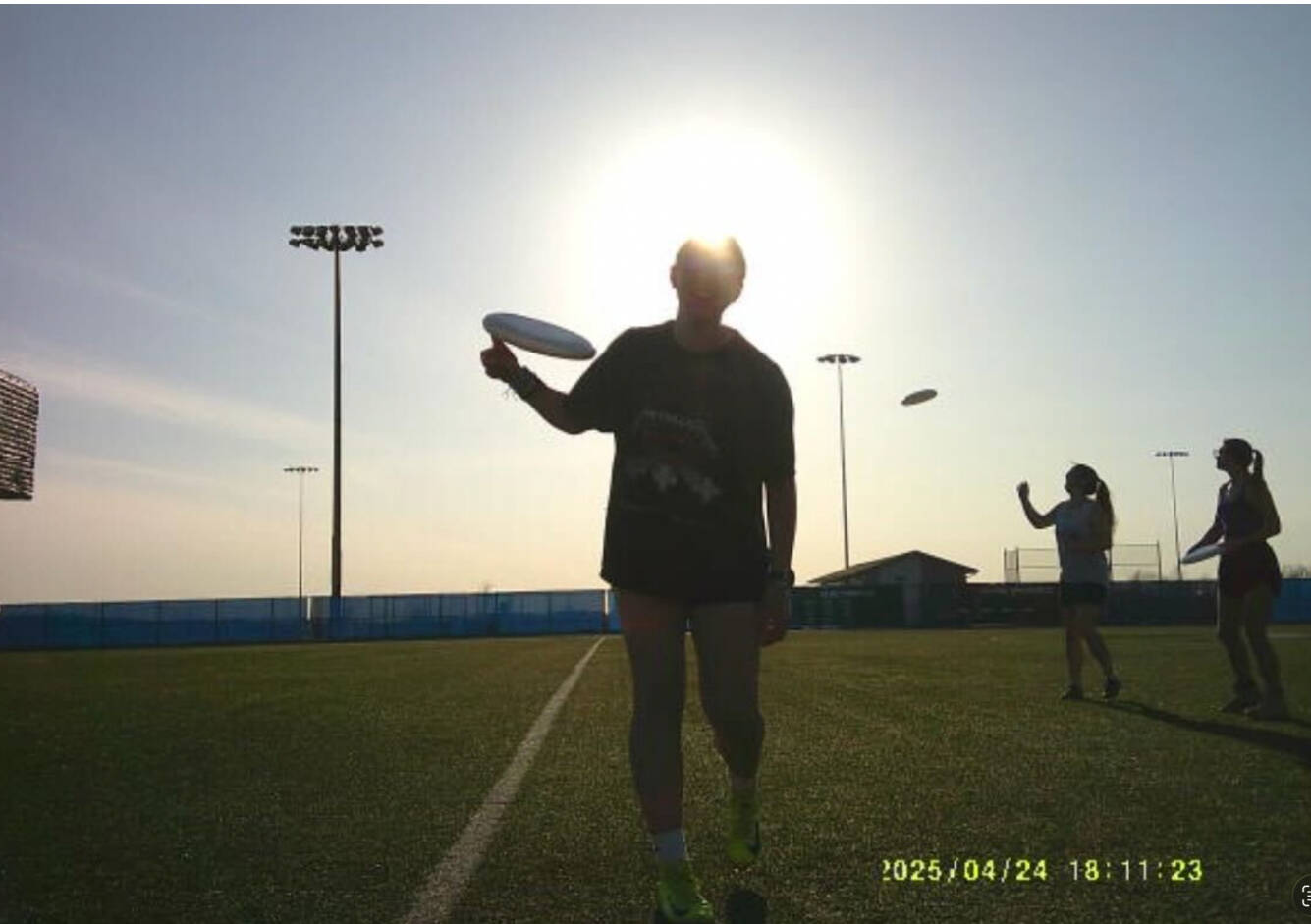 shadowy figure tossing a disc in the air